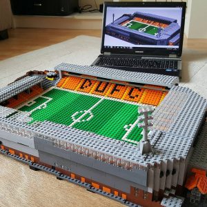 Lego football stadium model infront of laptop showing computer model of football stadium